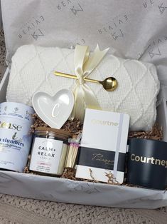 an open gift box containing coffee, candles, and other personal care items in it