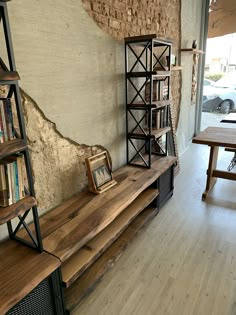 a wooden shelf sitting next to a wall with bookshelves on top of it