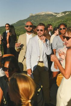 a group of people standing next to each other in front of a mountain side area