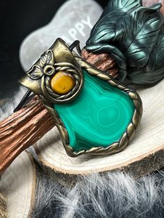 A beautiful amulet with powerful protective stones. Firstly, malachite, which is dedicated to the Nordic goddess Freya, sharpens the senses and makes you more alert to danger. It strengthens you particularly on an emotional level and thus promotes inner peace. The deep green, the color of nature, also promotes harmony and inner balance. The malachite is accompanied by a beautifully shimmering tiger's eye, which has always been known as a powerful protective stone that keeps evil curses and negative energies away. Both crystals are real natural stones and have fine natural stone structures. The trailer was designed, modeled, painted and varnished by me. I add a black faux leather chain to the pendant, but of course you can combine it with any other chain or bracelet. Dimensions of the penda Nordic Goddesses, Goddess Freya, Stone Structures, Inner Balance, Tiger's Eye, Leather Chain, Deep Green, Black Faux Leather, Inner Peace