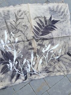 a piece of cloth with black and white flowers on it sitting on a brick sidewalk