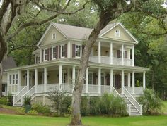 a large white house sitting on top of a lush green field