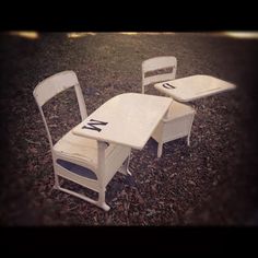 three white chairs sitting next to each other in the grass