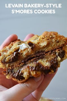 a close up of a person holding a piece of food in their hand with the words levii bakery - style smores cookies