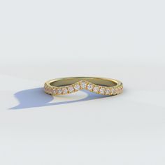 a yellow gold wedding band with three rows of diamonds on the top and bottom, set against a white background