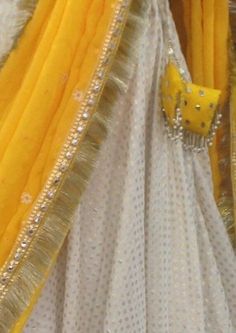 Haldi yellow lehenga with mirror work. The blouse is made of rawsilk with flutter sleeves in chiffon and all over mirror work. Skirt is made of brocade and has wide mirror work borders. Chiffon dupatta with sequins and mirror work. The dress will be made to order in your size. I'll send you a measurement sheet once you order for the measurements. Dress can be created in any color as the fabric is custom dyed. Please convo me if you have any questions or need any customisation. White And Yellow Lehenga For Haldi, Yellow Lehenga For Haldi, Mirror Work Skirt, Lehenga With Mirror Work, Yellow Haldi Outfit, Haldi Lehenga, Lehenga Yellow, Lehenga White, Brocade Suits