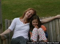 a mother and daughter sitting on a wooden bench