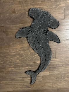 the rug is shaped like a fish on the floor in front of a wooden floor