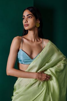 Editor's Note An easy to drape, transeasonal sari in sage green that can seamlessly flow from your everyday outfitting to evenings of celebration. Play up the lightweight organza with a statement blouse or a tonal cape for a striking ensemble that commands attention. Note: Stitched blouse worn by model is for styling purposes only. The sari comes with unstitched blouse fabric. Fabric: Habutai silk Color: Green Component: Sari and unstitched blouse piece. Occasion: Festive Size: Free size Sari le Office Sarees, Saree Shoot, Foundation Swatches, Statement Blouse, Simple Sarees, Green Saree, Century Clothing, Stylish Sarees, Silk Sari