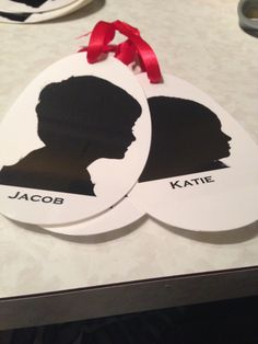 two white tags with black silhouettes on them that say jacob and kate