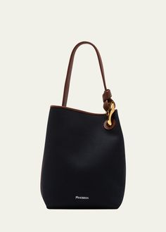 "Find JW ANDERSON Twill Canvas Chain Bucket Bag on Editorialist. This JW Anderson bucket bag is crafted from twill cotton and leather. It features a flat top handle with a chain accent and an open top with a magnetic closure. The bag measures approximately 12.2\"H x 9.5\"W x 6.2\"D and was made in Hungary." Evening Canvas Top Handle Shoulder Bag, Canvas Top Handle Shoulder Bag For Evening, Evening Canvas Shoulder Bag With Top Handle, Elegant Evening Canvas Bag, Evening Canvas Bag With Detachable Strap, Black Canvas Evening Bag, Black Canvas Bags With Gold-tone Hardware, Black Canvas Shoulder Bag With Gold-tone Hardware, Elegant Top Handle Canvas Bucket Bag