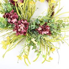 a wreath made out of flowers and greenery