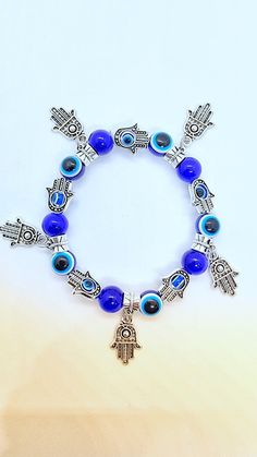 Hand Made Hamsa Hand Evil Eye Adjustable Blue Bracelet    * Brand New in package * Hand made from Evil eye glass and zinc * Beautifully made and very unique.  * High Quality * Elastic bracelet to fit all adults hands * Unisex Bracelet  * Please view pictures for all details as this bracelet is the one you gonna love for sure.   Additional information:-   The Hamsa or, "Protecting hand," is believed to be a way of averting and getting protection from the evil eye. It is believed that, in general, Blue Beaded Spiritual Stretch Bracelet, Blue Crystal Bracelet With 8mm Beads, Bohemian Blue Stretch Bracelet With 8mm Beads, Blue Bohemian Stretch Bracelet With 8mm Beads, Blue Spiritual Stretch Bracelet As Gift, Blue Nickel-free Crystal Bracelet For Gift, Blue Bohemian Metal Bracelets, Blue Nickel-free Crystal Bracelet Gift, Bohemian Blue Metal Bracelets