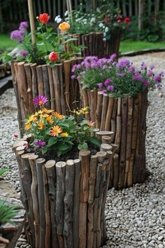 wooden planters with flowers in them sitting on gravel