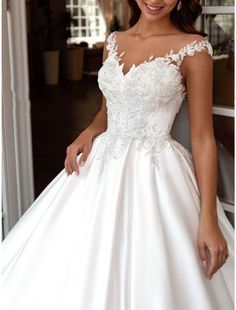 a woman in a wedding dress posing for the camera