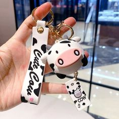 a hand holding a cow shaped key chain