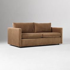 a brown couch sitting on top of a white floor