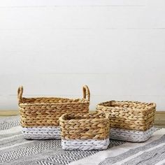 three woven baskets sitting on top of a rug