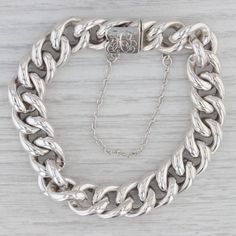 Metal: 830 Silver (stamped and XRF tested) Weight: 22.8 Grams  Stamps: 830 Chain Style: Curb Closure: Snap with safety chain Inner Circumference: 7 1/2" Width: 12.2 mm Each piece is thoroughly examined and refinished as needed by our professional jewelers, graded by our in-house GIA (Gemological Institute of America) Graduate Gemologist, and inspected for quality before being carefully packaged and promptly shipped. [SKU: S01037] phd Classic Curb Chain Bracelet, Classic Cuban Link Bracelet, Classic Cuban Link Bracelet With Polished Finish, Classic Silver Cuban Link Bracelet, Formal Silver Cuban Link Bracelet, Classic Silver Cuban Link Bracelet With Oval Links, Classic Cuban Link Bracelet With Oval Links, Classic Engraved Cuban Link Bracelet For Formal Occasions, Classic Engraved Oval Link Chain Bracelet