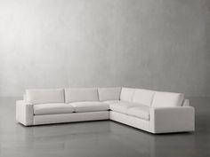 a white couch sitting on top of a gray floor