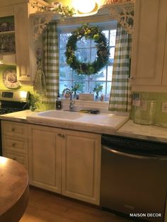 the kitchen is decorated for christmas with wreaths on the window sill above the sink