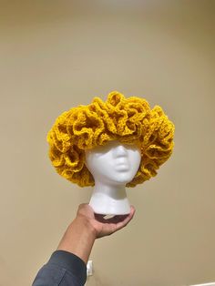 a person is holding up a wig made out of yarn