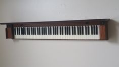 a wall mounted shelf with a piano keyboard on it's side, hanging from the wall