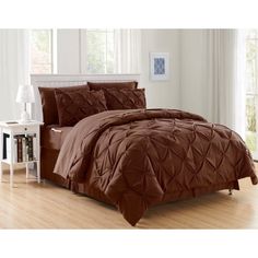 a bed with brown comforter and pillows