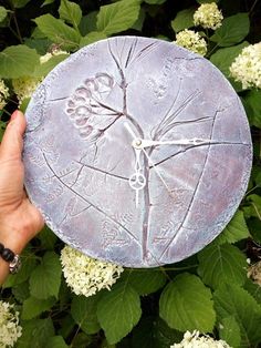 a person holding up a piece of art that looks like a tree