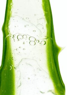 a close up view of a green bottle with water droplets on it's surface