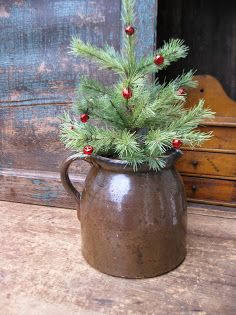 a small christmas tree in a brown pitcher