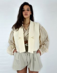 Made in France.Product Description- Short sleeveless jacket,- Beige cotton canvas,- Unstructured glue,- Fully lined, The MUSKEG Jacket is a variation of the DOLMA coat that you love. Designed in beige cotton canvas, the MUSKEG jacket retains the pure, graphic lines of the Louise Marcaud brand while offering the possibility of layering. Over a shirt, sweater or coat. The idea is to play with the codes of layering. Its short cut, and its light material, are ideal for creating sophisticated and rel Beige Cotton Vest Outerwear, Beige Cotton Vest For Winter, Beige Cotton Vest, Chic Cream Cotton Outerwear, Fitted Beige Vest Outerwear, Beige Fitted Vest Outerwear, Fitted Beige Cotton Outerwear, Chic Cotton Vest For Winter, Off White Cotton Outerwear For Fall