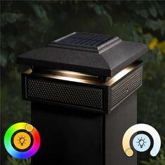 a solar powered light on top of a black box with two different colored lights next to it