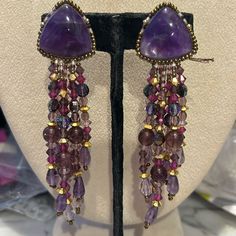 So Gorgeous!!!!! This Is A Pair Of Authentic Chipita Earrings From The 1980s. We Carried The Collection In Our Wearable Art Gallery In Ny And Just Uncovered Several Pieces That Have Been Packed Away After We Moved Locations. These May Be Over 40 Years Old But They Are Brand New. They Are Designer Stamped. This Pair Is Beautiful. It Features Genuine Amethyst Semi Precious Stones And Amethyst Cut Crystals. There Are Gold Crystal Accent Beads. These Are 4” Long And Clip On Style Earrings Signed Sto Elegant Lavender Beaded Earrings, Purple Drop Earrings With Gemstone Accents, Purple Gemstone Accented Drop Earrings, Elegant Lavender Beaded Earrings With Dangling Beads, Purple Clip-on Earrings, Handmade Bohemian Purple Crystal Earrings, Handmade Purple Amethyst Chandelier Earrings, Handmade Purple Bohemian Crystal Earrings, Bohemian Purple Dangle Crystal Earrings