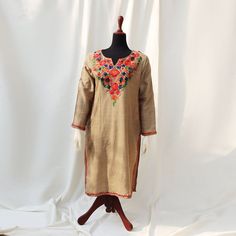 Discover the epitome of elegance with our Beige Base Color Kurti Shirt, adorned with exquisite Aari kashmiri embroidery. The detailed patterns around the shoulders and neck create a charming contrast to the solid beige outfit, featuring stunning embroidery in pink, blue, and orange hues. Made from high-quality, soft pashmina wool, this frock ensures comfort and style for the summer and spring seasons. Its detailed embroidery and graceful patterns make it a perfect choice for semi-formal and formal events. Embrace versatility with this article, pairing it effortlessly with simple jewelry and statement shoes for various occasions. Ideal for both indoor and outdoor use, each uniquely crafted piece is available in limited quantity and sizing, ensuring you stand out with exclusivity and finesse Navratri Long Sleeve Salwar Kameez With Embroidered Border, Traditional Embroidered Dress With Dabka Work For Spring, Festive Multicolor Embroidered Kaftan With Dabka Work, Designer Multicolor Embroidered Dress For Eid, Embroidered Straight Kurta With Zari Work For Navratri, Bohemian Embroidered Dress With Zari Work, Traditional Spring Embroidered Dress With Dabka Work, Embroidered Straight Kurta Dress With Zari For Navratri, Festive Multicolor Embroidered Dress With Dabka Work