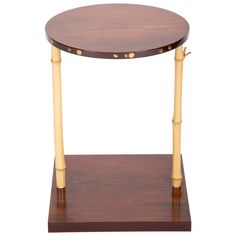 a small wooden table with two legs and a round top on a wood stand against a white background