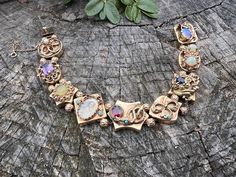 Set in 14k yellow gold, this enchanting multi stone slide bracelet dates from the 1940's. Each of the 9 charming slides are unique.  They include  pearl, amethyst, enamel, garnet,  opal  and sapphire, creating a story of its own.  It  comes together for an energetic look draped in magnificence.   The bracelet measures 8 1/8" long.  It measures 1/2" wide.  The bracelet weighs 51.70 grams. It is marked 14k.  BR 956 SIX MONTH LAYAWAY AVAILABLE Heirloom Gold Bracelets With Multi-stone, Heirloom Gold Multi-stone Bracelets, Antique Multi-stone Bracelets For Formal Occasions, Antique Multi-stone Bracelet For Formal Occasions, Antique Multi-stone Bracelets As Gift, Antique Multi-stone Bracelet As Gift, Heirloom Multi-stone Bracelets For Formal Occasions, Heirloom Yellow Gold Multi-stone Bracelets, Heirloom Gold Gemstone Bracelets