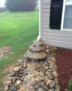 a rock waterfall in front of a house