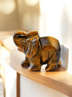 an elephant figurine sitting on top of a wooden shelf