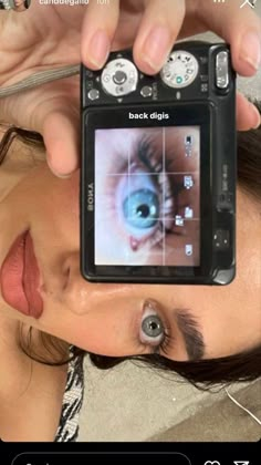 a woman is holding up a camera to take a photo with an eyeball on the screen