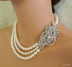 "This glamorous necklace has a vintage inspired brooch and Swarovski pearls in white. Brooch has clear rhinestones and leaves, and measures 3\" by 1 1/2\" at its widest point. Pearls measure 8, 6 mm in the middle strand accented with rhinestone roundelles. Necklace is 17\" long inner strand. Finished off with a silver hook and eye closure. Pearls can be substituted with ivory/cream color and size adjusted. Convo me with color preference and if you need me to adjust the length and will be happy t