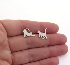 "Mismatched cat earrings, sterling silver dangle earrings for animal lovers. Minimalist, handmade jewelry for women. Playful earrings for cat lovers. Two different cats, one is standing with his tail up, and the second one is stretching. These cute earrings are 100% handmade by me. I saw the cat figures by hand from a durable, solid sterling silver sheet, file them, solder the loops, add the ear wires, and give the cats a matte finish. The earrings are also available as matching (mirroring) cat Different Cats, Kitten Earrings, Cat Earrings Studs, Sterling Silver Cat, Silver Cat, Mismatched Earrings, Cat Jewelry, Cat Lover Gift, Cat Earrings