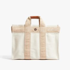 a white and tan tote bag sitting on top of a table