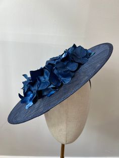 This beautiful navy blue coloured Sinamay cartwheel fascinator is covered in ombré blue hydrangeas. A blue velvet ribbon trim sits around the rim of the crown of the fascinator. A stunning Ascot piece. The fascinator sits on a headband to secure in place.  This Fascinator is stunning, perfect for all summer events, weddings and races. Brand New. The sinamay fascinator measures approximately 35cm in diameter. If you need your item by a certain date please let me know. Made in the UK. Custom orders are welcome. Many more items are available in our Shop. Returns Please notify us within 3 days of receiving your item if you intend to return it. We allow 7 days from the date of receipt of the headpiece to return it to us, our returns requirements are that it is returned properly packaged to prev Navy Blue Fascinator, Blue Velvet Ribbon, Hydrangea Petals, Princesa Sophia, Pink Hydrangeas, Blue Fascinator, Sinamay Fascinator, Royal Ascot Hats, Sinamay Hats