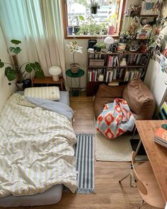 a small bedroom with a bed, desk and bookshelf in the corner next to a window