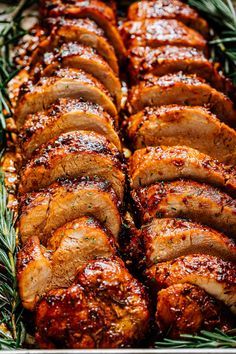 sliced pork roast in a pan with rosemary sprigs on the side, ready to be served