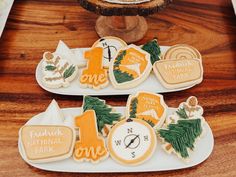 decorated cookies on plates sitting on a table next to a plate with trees and other decorations