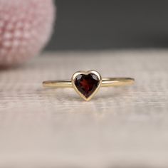 Ashly Follow your heart and it will lead you to our gold rings. This red heart ring has a beautiful heart shape cut and would make the perfect gift for her. Available in Yellow Gold, White Gold, and Rose Gold. - Handmade - Solid Gold- Natural Garnet- Total Garnet Carat Weight: .48 ctw- Bezel Setting Size: 7.5 mm- Ring Band: 1.4 mm All pieces come beautifully boxed in suede pouches you can always use (which really comes in handy when traveling!) Dainty Garnet Ring, Garnet Heart Ring, Heart Gem Ring, Vintage Promise Rings, Red Heart Ring, Promise Ring Gold, Heart Ring Gold, Gold Garnet Ring, Golden Rings