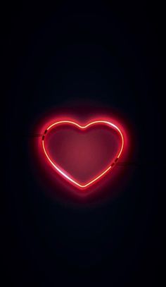 a red neon heart on a black background