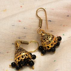 "Small Golden Jhumka Earrings, Black Color Stones Beaded Jhumkas, Antique Golden Finish, Beautifully carved Handmade Design Description Stone Type: Beads Metal: Brass Material: Alloy, Beads Length: 4Cm. Weight: 11Gm. Fastening: Ear Wire Occasions: Gifting, Party wear, Casual Wear, Marriage Occasion Packet Contains: 1 Pair Earring Colours Available: Golden Why This Product? Antique Golden Small Jhumki  with beautiful Black Beads Trendy & Fashionable. 'A dangle from the past' Filled with an Artisan's authenticity and \"The Happy Cart\" Passion. We regret the things, we don't buy  Feedback Do contact us if you have queries regarding this product or any problem with your purchase. We are here to help you. Do give us an opportunity to resolve your issues. Positive Feedbacks are always welcome. Black Round Beads Jewelry For Diwali, Handmade Jhumkas For Rituals And Festivals, Adjustable Festive Earrings For Celebration, Traditional Black Beaded Jewelry For Festivals, Traditional Earrings With Oxidized Finish And Adjustable, Traditional Earrings With Oxidized Finish, Handmade Brass Jhumkas For Festivals, Traditional Oxidized Finish Earrings, Bohemian Black Jhumkas For Gift